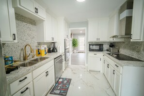 A modern kitchen with white cabinetry, granite countertops, and stainless steel appliances. - Family or work group relaxation at a peaceful place in the heart of Midland (Midland)