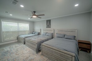 A bedroom with two beds, a ceiling fan, recessed lighting, a window with blinds, and a nightstand. - Family or work group relaxation at a peaceful place in the heart of Midland (Midland)