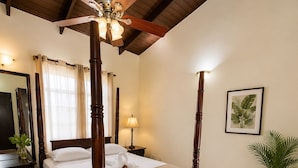 A four-poster bed with a ceiling fan, a bedside lamp, a framed botanical print on the wall, and a potted plant. - Villa Augustas (Gros Islet)