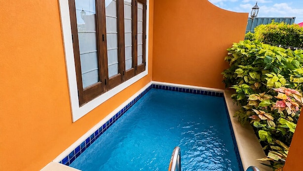 A swimming pool with a tiled edge, a window with wooden frames, and a metal ladder. - Villa Augustas (Gros Islet)