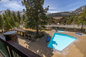 Un espace piscine avec un jacuzzi, un barbecue et une vue sur la montagne.