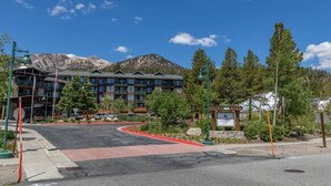 A multi-story hotel with a mountain backdrop, a red curb, and a sign indicating the name 'Hunter Springs.' - Juniper Springs Resort with Panoramic Views - Luxury Mountain Escape (Mammoth Lakes)
