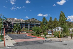 Ein mehrstöckiges Hotel vor einer Bergkulisse, mit rotem Bordstein und einem Schild mit dem Namen 'Hunter Springs'.