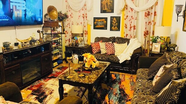 Ein Wohnzimmer mit Fernseher, Sofa, Couchtisch und Dekorationselementen.