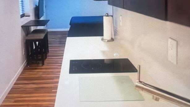 Eine Küche mit Spüle aus Edelstahl, einer Arbeitsplatte und Holzböden.