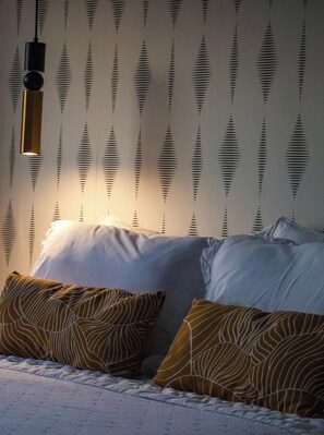 A bedroom with a bed, pillows, and a wall with a striped pattern. - Alazne Enea – A Place with Soul in Bermeo, Perfect for Couples and Families (Bermeo)