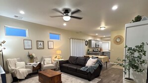 A living room with a sofa, armchairs, a coffee table, and a dining area with a table and chairs.