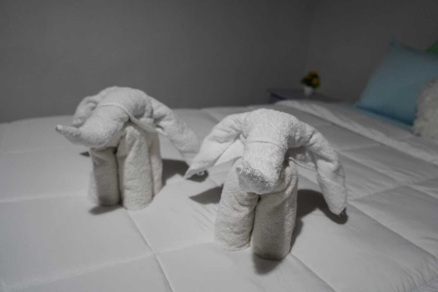 A bed with two towels shaped like animals.