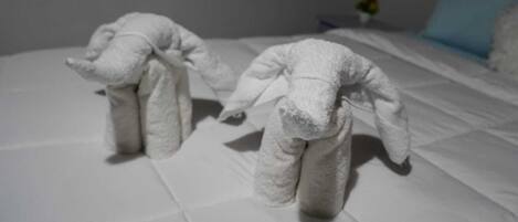 A bed with two towels shaped like animals.