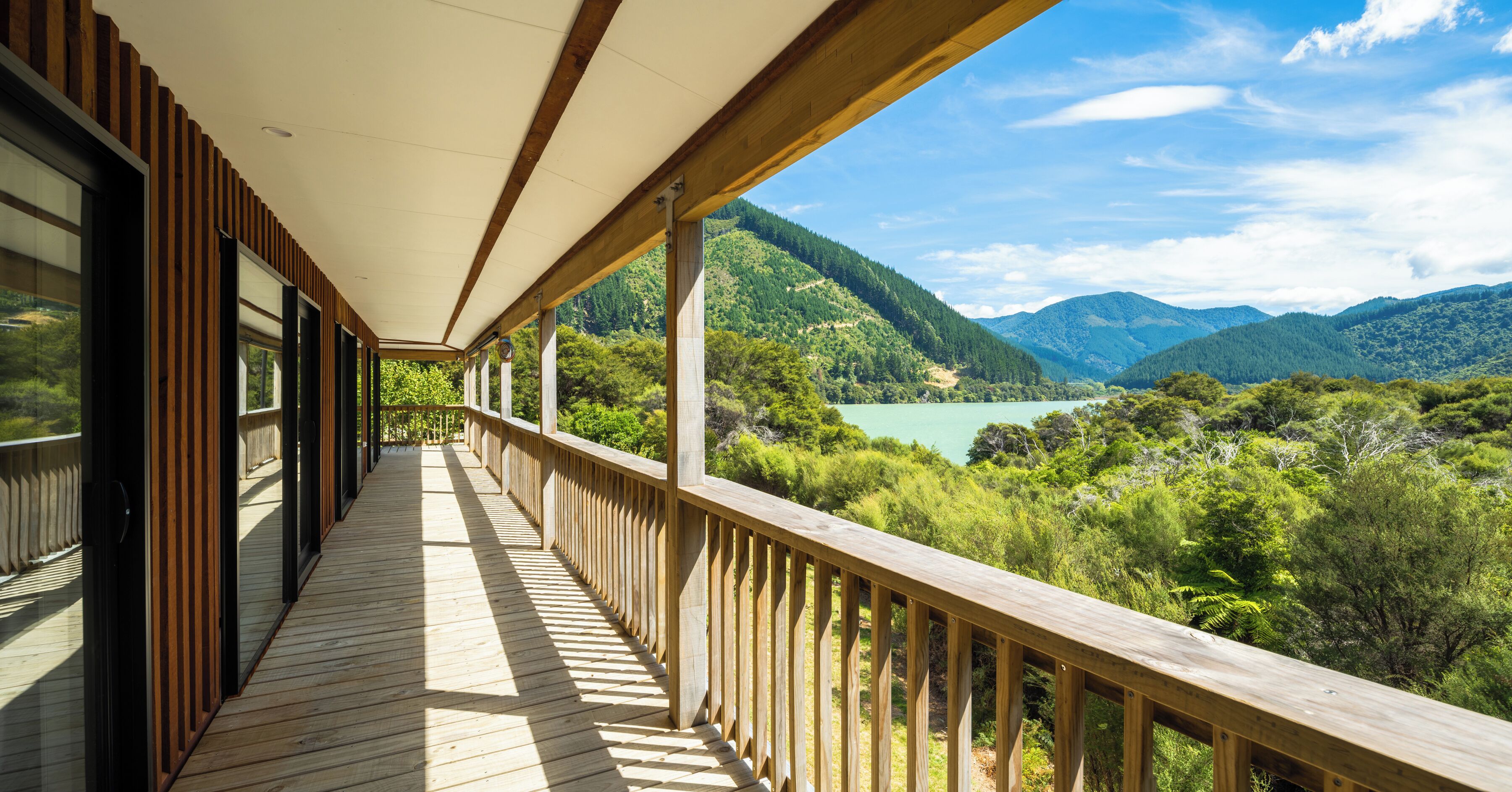 A wooden deck with a view of a lake and mountains.