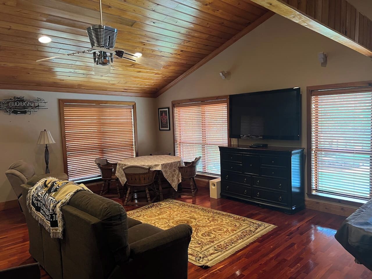 A living room with a dining table, chairs, a sofa, a TV, and a fireplace.