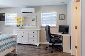 A bedroom with a bed, dresser, desk, chair, TV, and two windows with blinds. - Entire House with Seasonally Heated Pool and Waterfall in Naples (Naples)