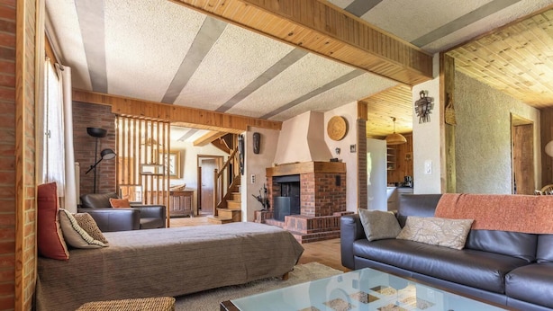A cozy living room with a fireplace, leather sofa, and a glass coffee table. - La Pruneyre - ESPINCHAL (ESPINCHAL)