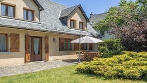 A two-story house with a stone-paved driveway, wooden shutters, and a patio with outdoor furniture. - La Pruneyre - ESPINCHAL (ESPINCHAL)