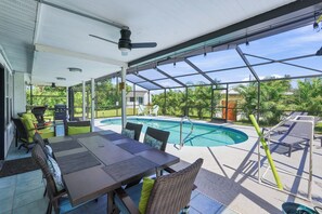 A covered outdoor area with a pool, seating, and a ceiling fan. - Nokomis Sunset Retreat  w/Pool - 8 mins to Beach (Nokomis)