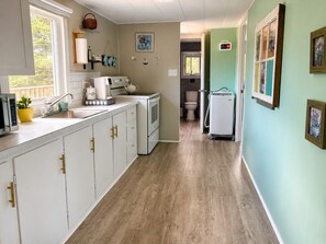 A kitchen with white cabinets, a coffee maker, and a microwave. - Little Tracadie Retreat (Grand Tracadie)