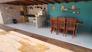 A kitchen with a tiled backsplash, wooden chairs, and hanging pendant lights. - Abade House - 4 Bedrooms with Air Conditioning - Gourmet Area/Pool - Excellent Location - Itacaré (Itacaré)