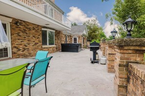 Eine Terrasse mit Tisch, Stühlen, einem Grill und einer Gasflasche.