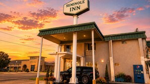 Seminole Inn com entrada coberta, área de estacionamento e máquina de refrigerantes Pepsi.