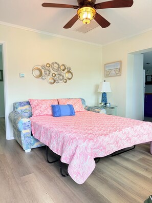 A bedroom with a bed, a ceiling fan, a wall clock, a decorative wall piece, and a painting. - Nokomis Sunset Retreat w/Patio 8 mins to  Beach (Nokomis)