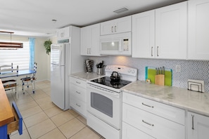 A modern kitchen with white cabinets, a microwave, a stove, and a refrigerator. - Nokomis Sunset Retreat w/Patio 8 mins to  Beach (Nokomis)