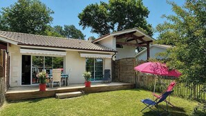 Uma casa com varanda, área coberta e quintal cercado.