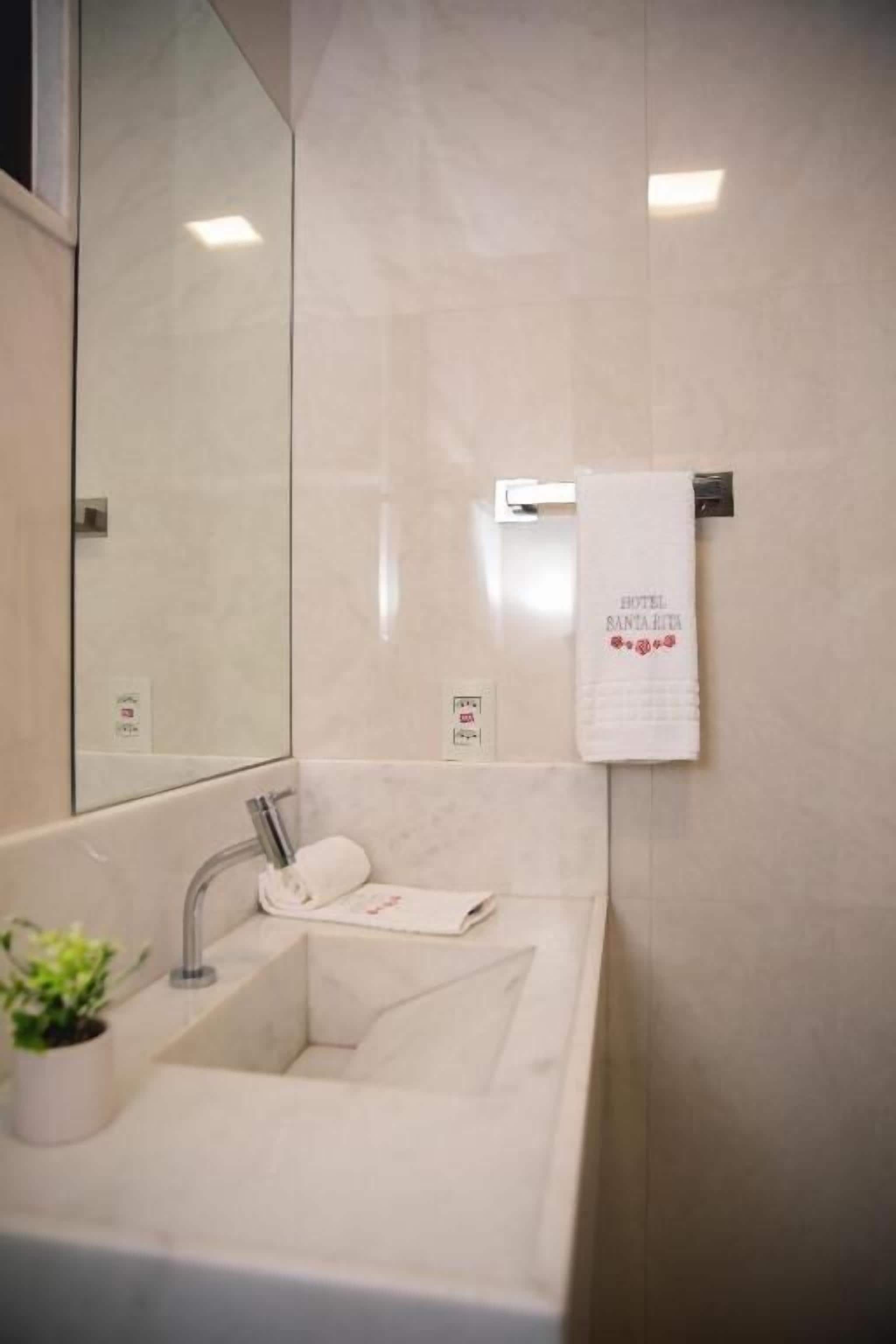 Un bagno con lavandino, porta asciugamani e specchio.