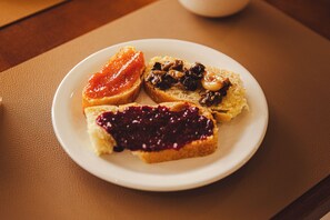 Un plato con tres tipos diferentes de tostadas cubiertas con diversas mermeladas y untables.