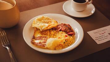 A plate of food with a cup of coffee and a napkin on a table.