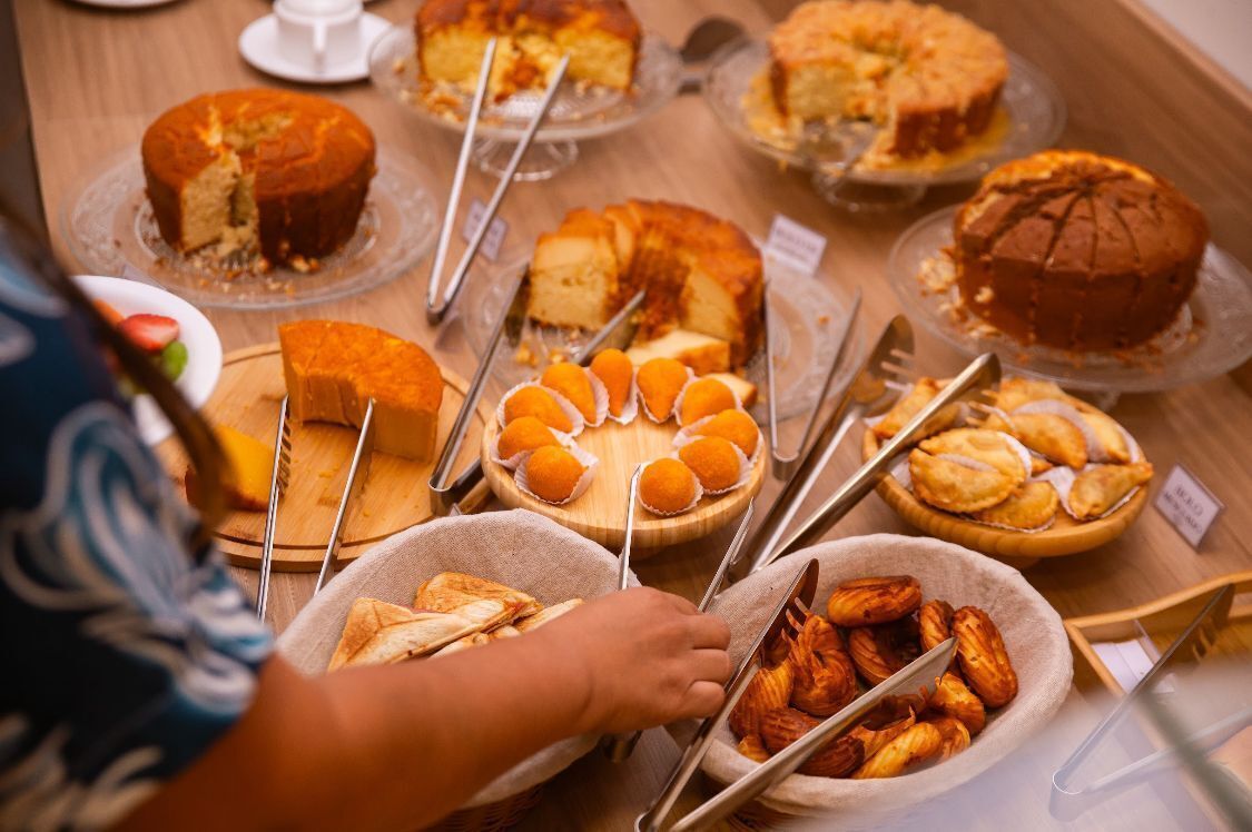 A buffet with various food items including cakes, pastries, and bread.