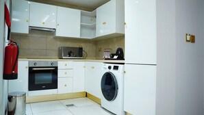 Una cocina compacta equipada con microondas, horno y lavadora.