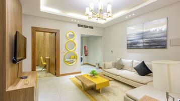 A modern living room with a sofa, coffee table, and a TV mounted on the wall.