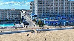 Ein Hotel mit mehreren Stockwerken, einem Poolbereich und einem Strand.
