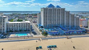 Ein Küstenhotel mit mehreren Gebäuden, einem Poolbereich und einem Strand.
