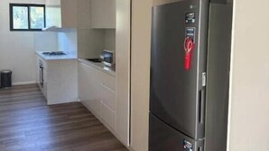 A modern kitchen with a built-in refrigerator, a stove, and a microwave. - Luxury Fully Furnished Acreage Retreat – Dural (Dural)