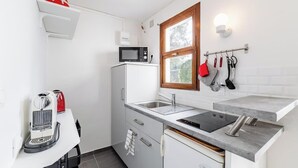 Et lille køkken med mikrobølgeovn, vask og en lille bordplade.