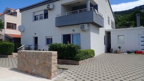 Un edificio moderno a due piani con un balcone, un'antenna parabolica e condizionatori.