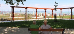 A park with a wooden bench, a gazebo, and a view of a marina. - Holiday home near the town centre (Siófok)