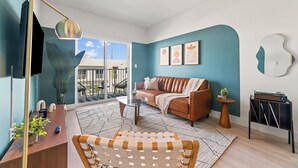 Un salon moderne avec un canapé, une table basse et une petite table d’appoint.