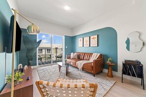 A modern living room with a sofa, coffee table, and a small side table. - 2BR Luxury King Suites + Parking Clean and New (Hallandale Beach)