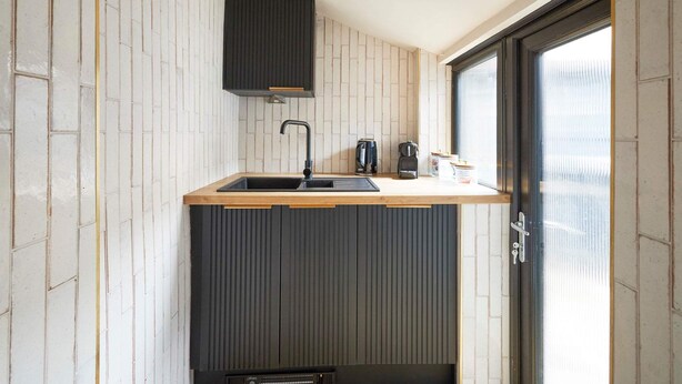 A kitchen with a wooden countertop, a black faucet, and a window with blinds. - Host Stay - Hecklers Nook (Barnard Castle)