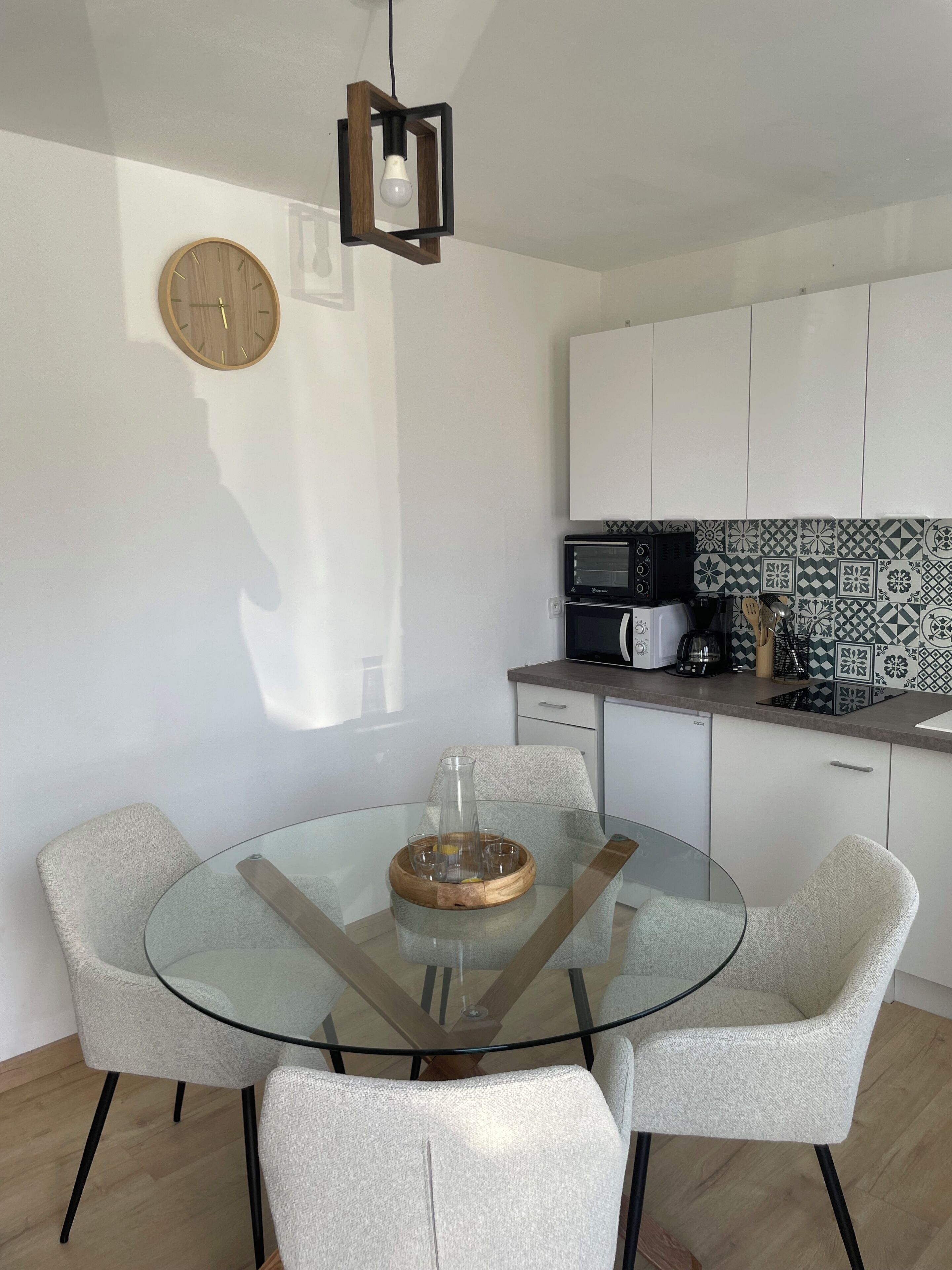 A modern kitchen with white cabinets, a microwave, and a coffee maker.