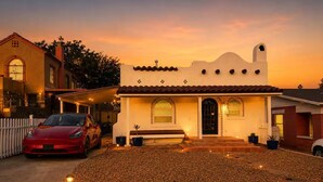 Une maison avec un toit en tuiles, un porche à l’avant et une allée.