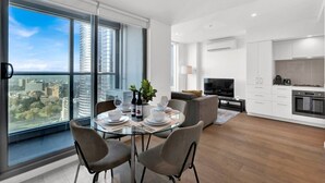 Un apartamento moderno con comedor, cocina y amplios ventanales con vistas a la ciudad.