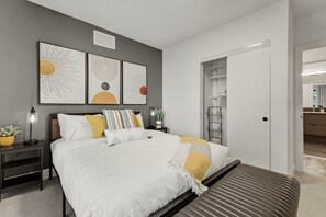 Een moderne slaapkamer met een bed, nachtkastjes en kunst aan de muur.