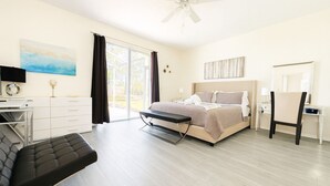 A bedroom with a bed, a desk, a chair, a ceiling fan, and a large window. - Pool Oasis Near Disney, Games & TV, Family Time (Davenport)