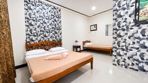 A hotel room with two beds, a wooden headboard, a small bedside table with a vase, and a wall-mounted air conditioning unit. - La Petite Pension (Puerto Princesa)