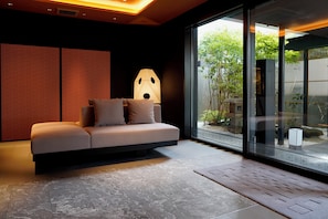 Ein modernes Interieur mit einer Couch, einer besonderen Lampe und Blick durch große Glasüren.