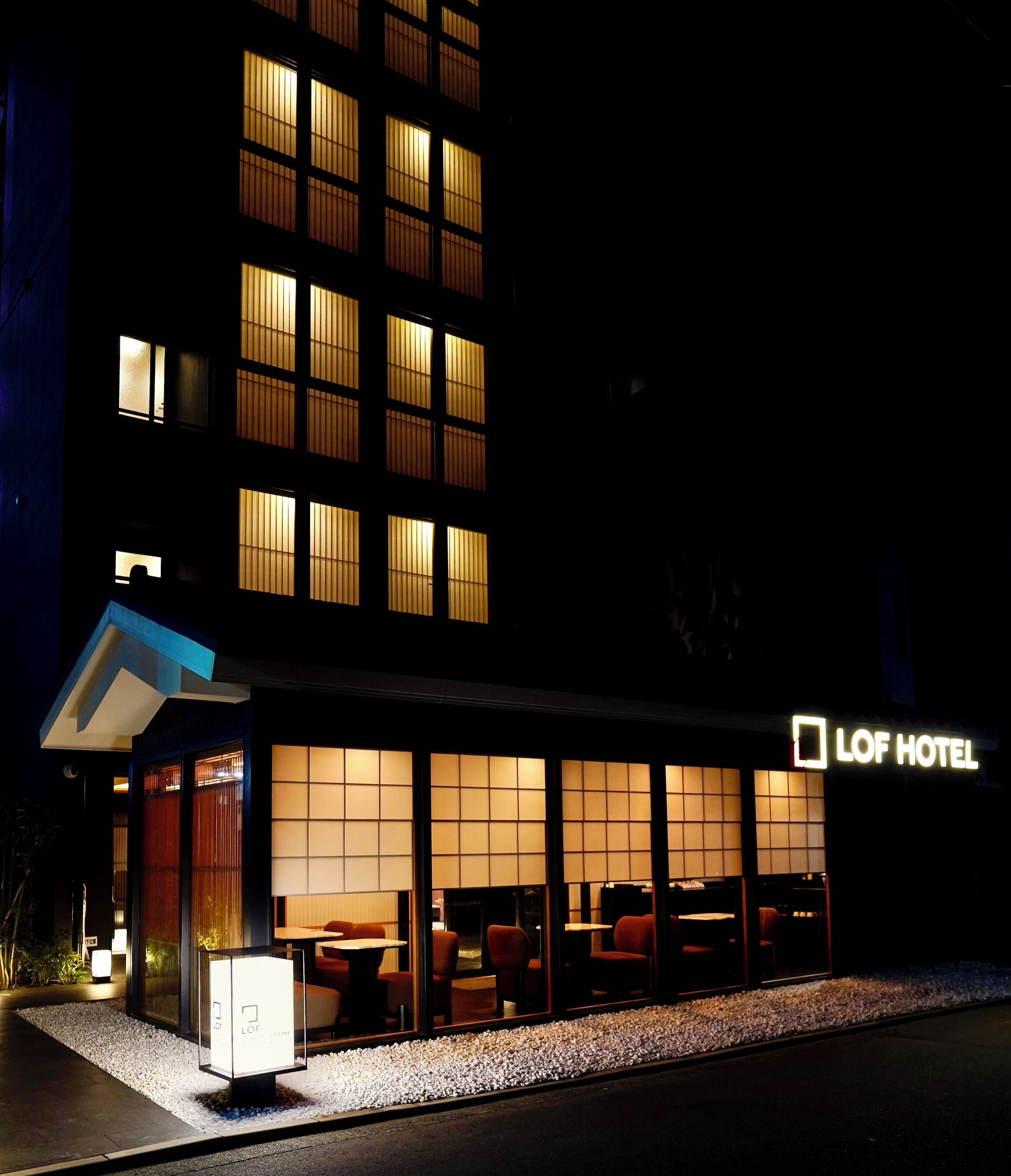 A hotel with a modern facade, large windows, and a sign reading 'LOF HOTEL.'