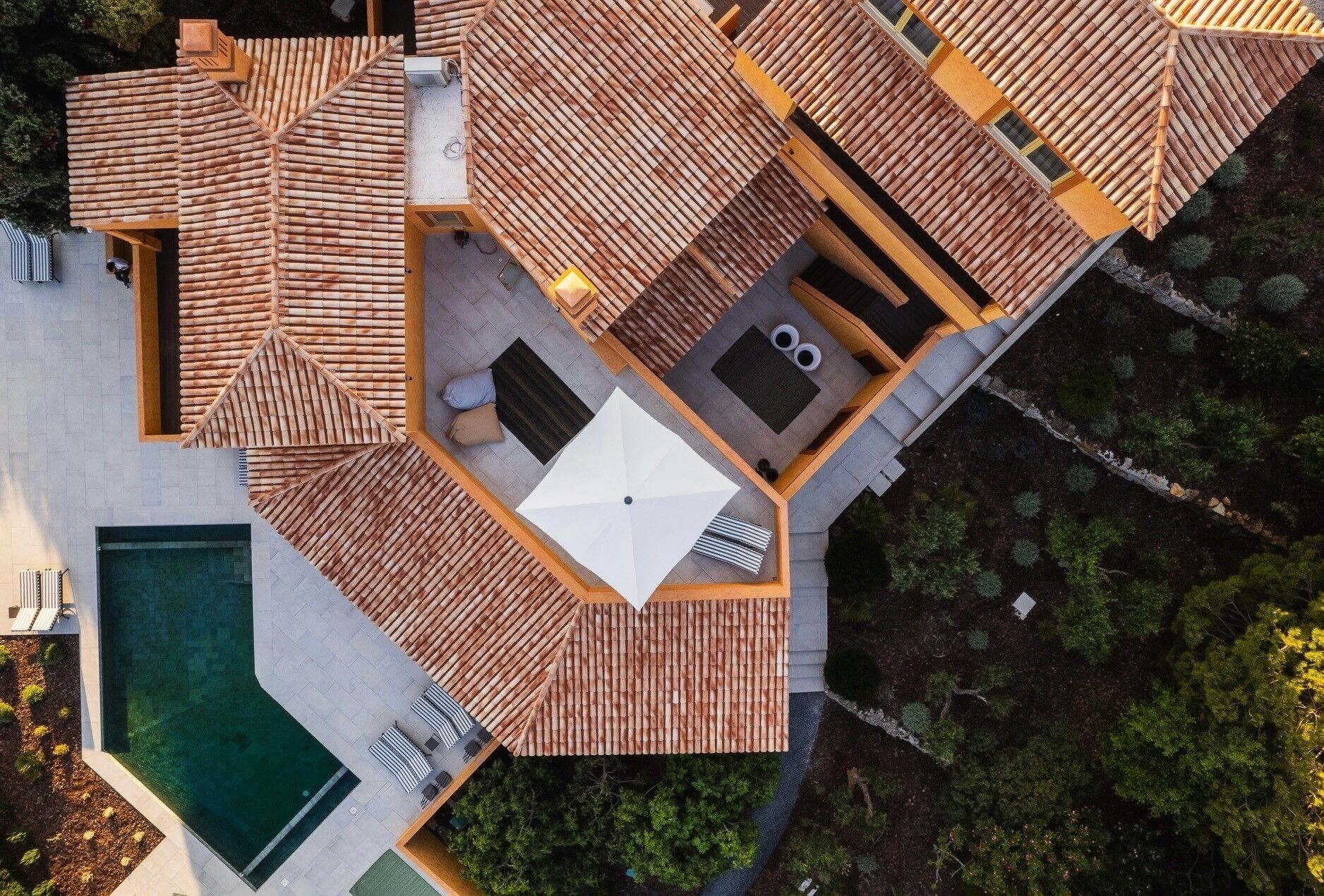 Eine Dachterrasse mit Pool, Sitzgelegenheiten im Freien und einer Whirlwanne.